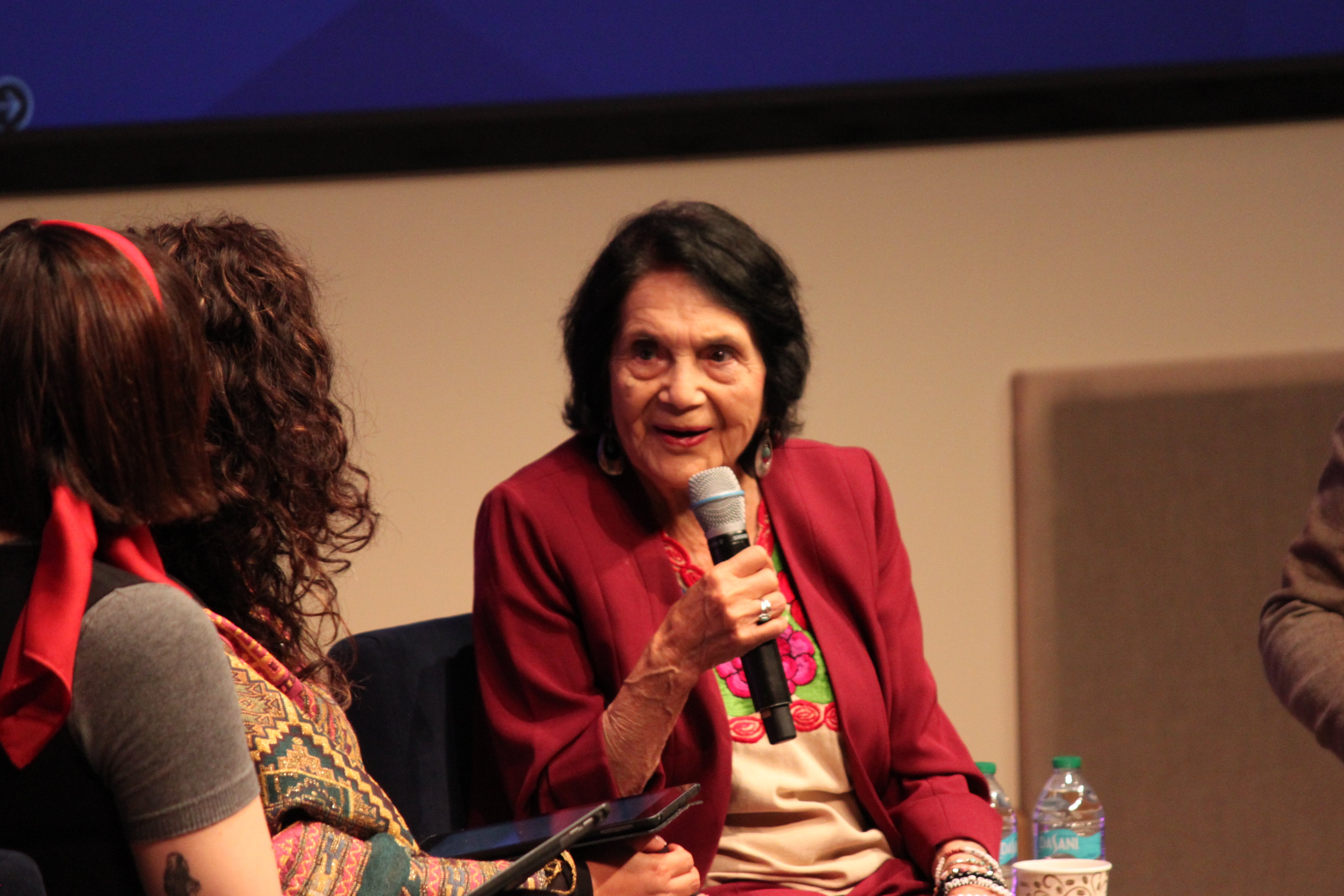 Dolores Huerta speaking into microphone onstage