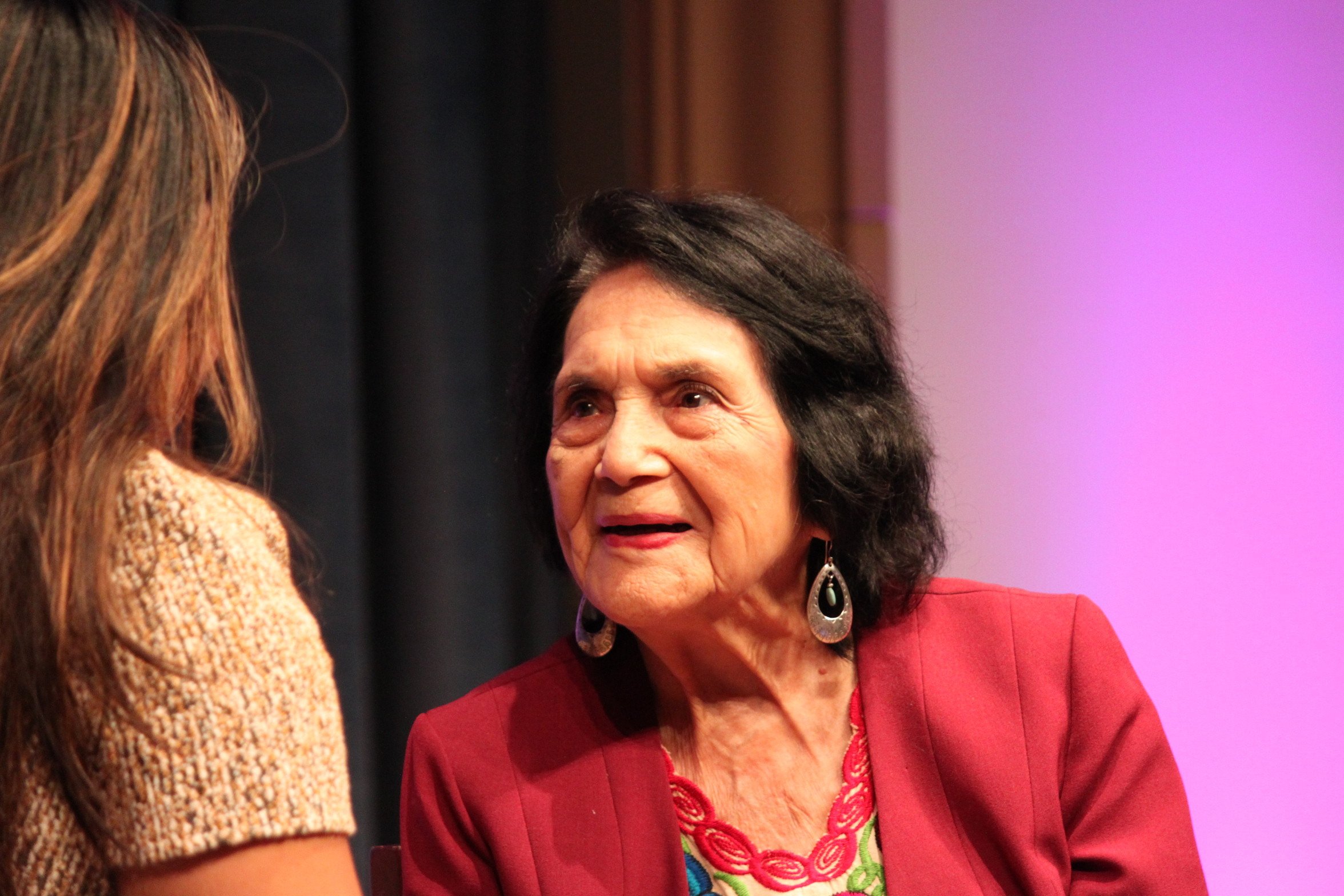Dolores Huerta smiling while talking to an audience member