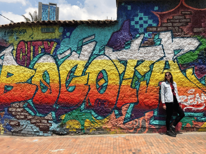 Nicole next to a graffiti wall in Bogota