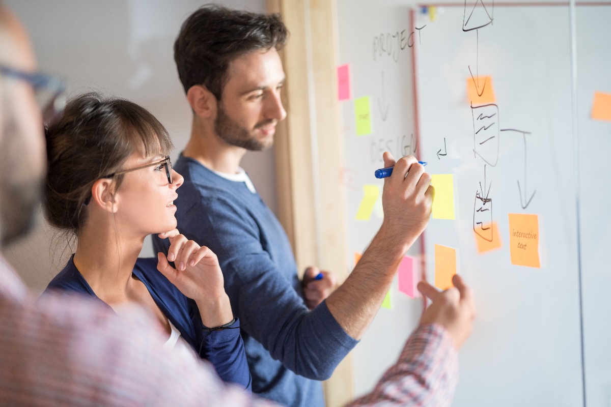 man and woman brainstorming on whiteboard